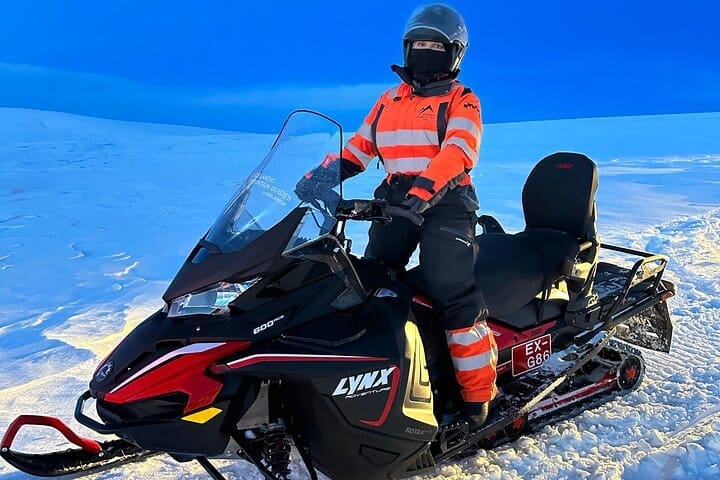 Moto de nieve en un glaciar y círculo dorado en un Superjeep